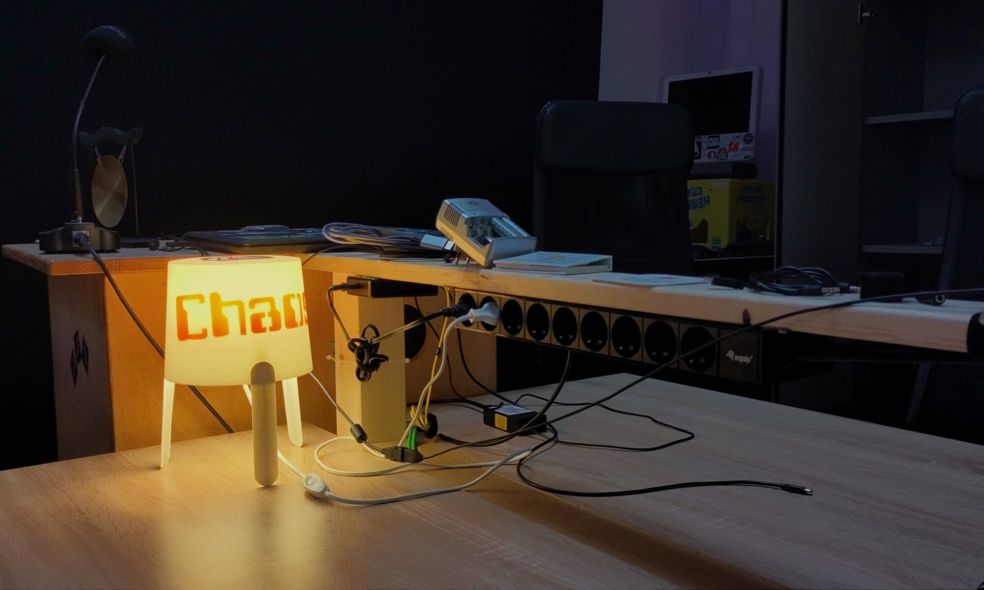 der Hackcentertisch mit der Chaosdorf-Leuchte, dahinter das Pult